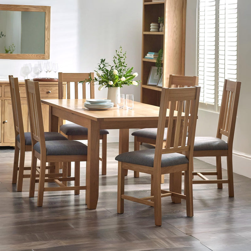 Dining room with wooden table and chairs in a well-lit room.