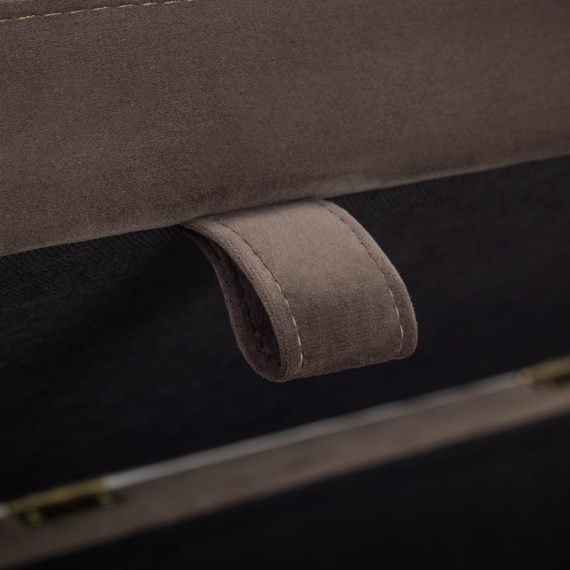 Close-up of a brown fabric handle on a product with a dark background