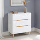 White dresser with gold handles against a gray wall