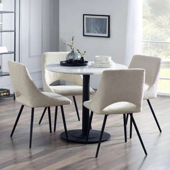 Dining room with a round table and four chairs in a well-lit room.