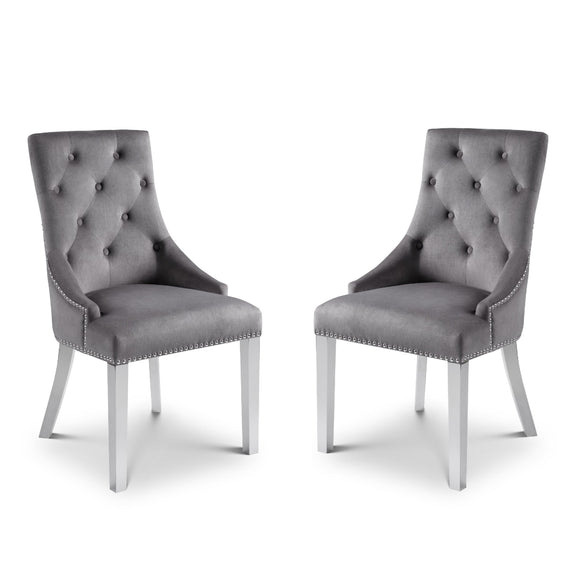 Two gray tufted chairs with silver legs on a white background