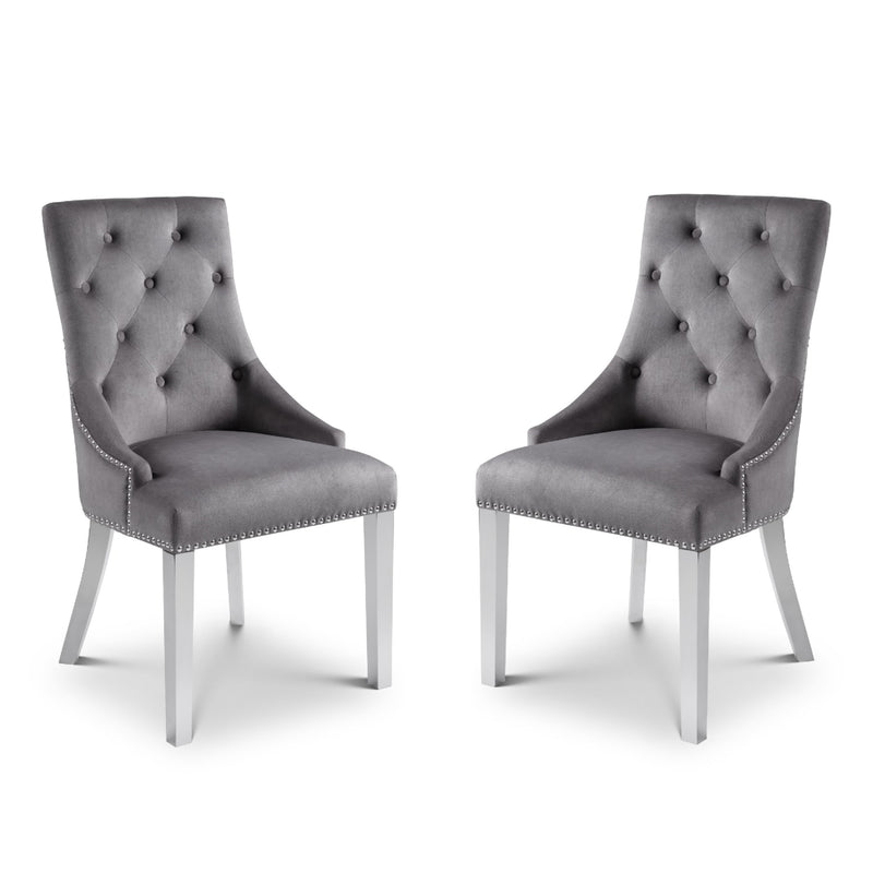 Two gray tufted chairs with silver legs on a white background