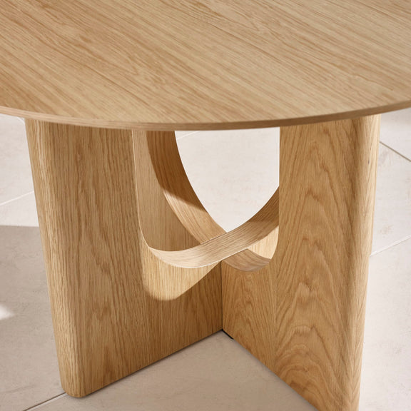 Wooden table with a unique base design on a light background