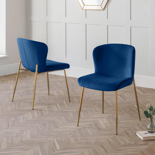 Two blue chairs with gold legs on a wooden floor.