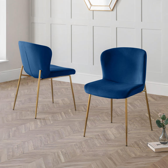 Two blue chairs with gold legs on a wooden floor.