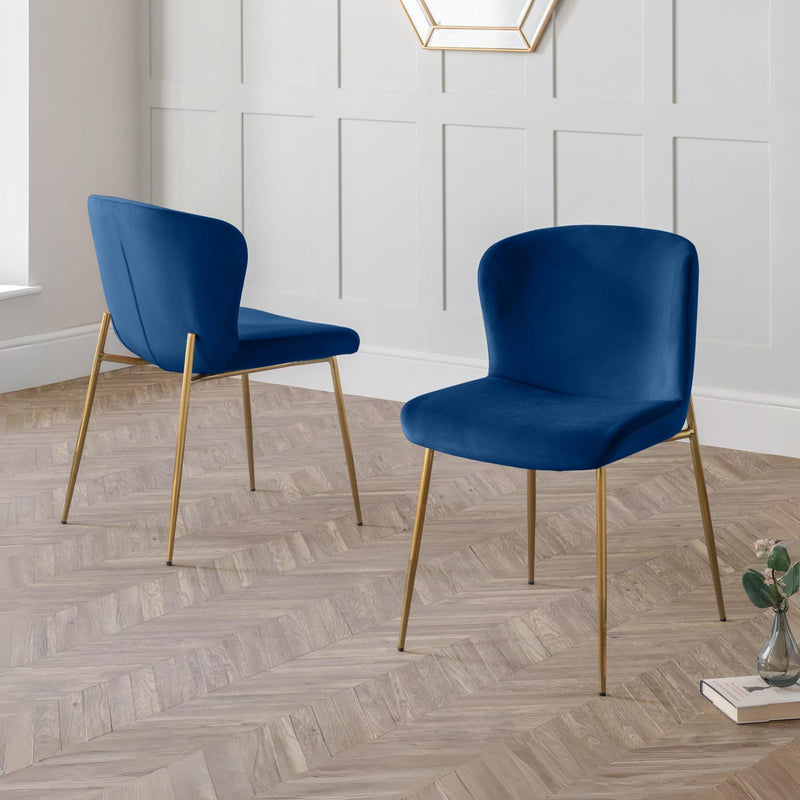 Two blue chairs with gold legs on a wooden floor.