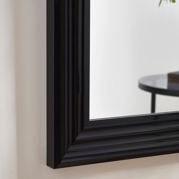 Black-framed mirror on a light-colored wall