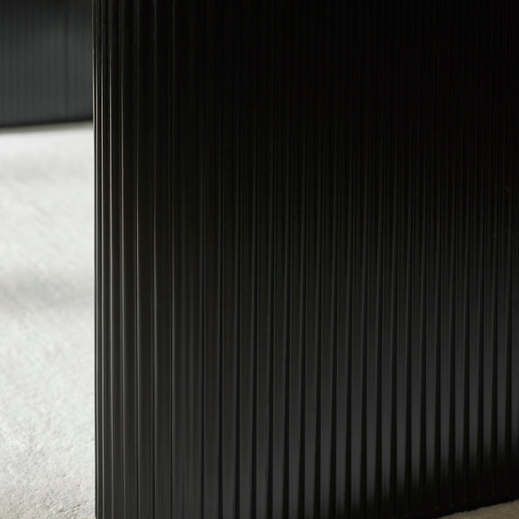 Close-up of a textured black surface with a white fabric background