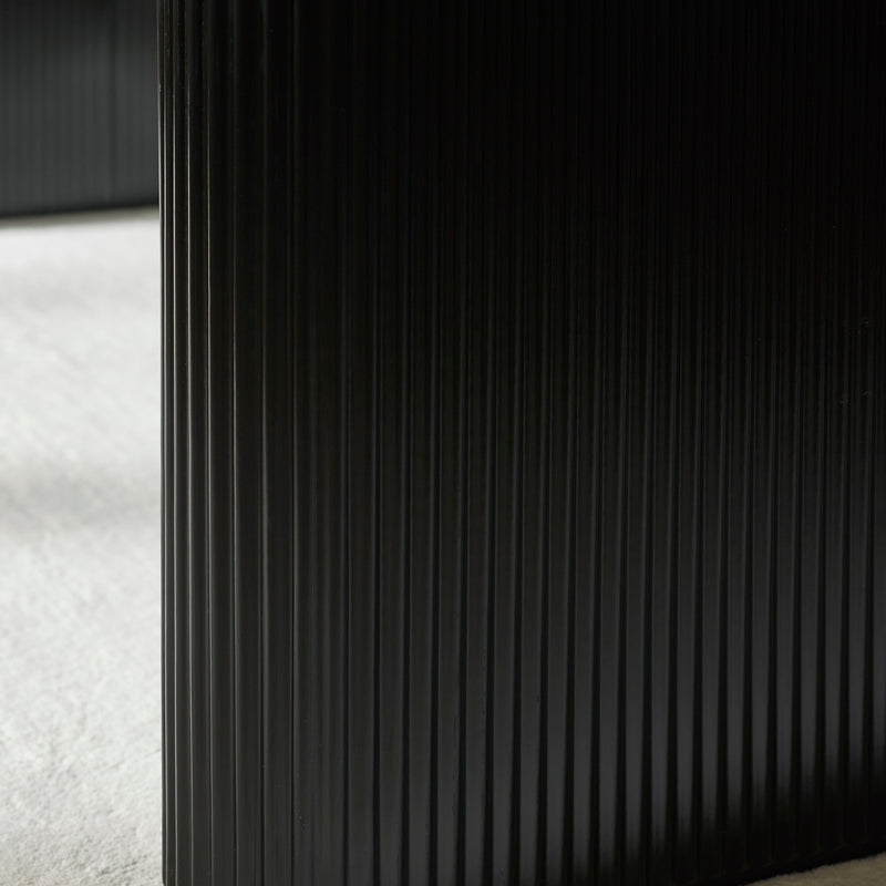 Close-up of a textured black surface with a white fabric background