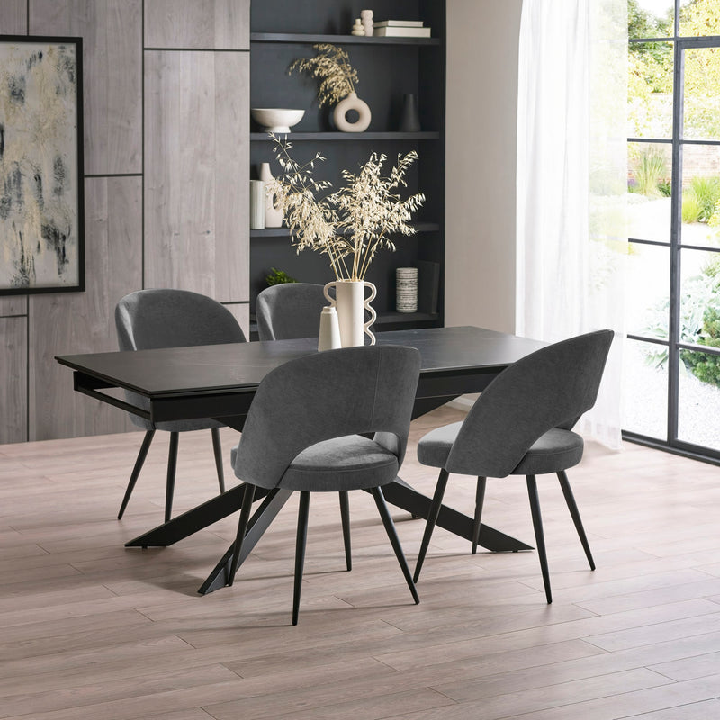 Dining room with a black table and gray chairs in a modern interior setting.