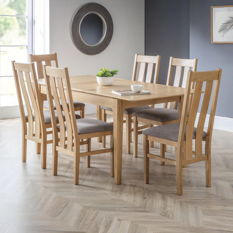 Dining table set with chairs in a room with a mirror and window.