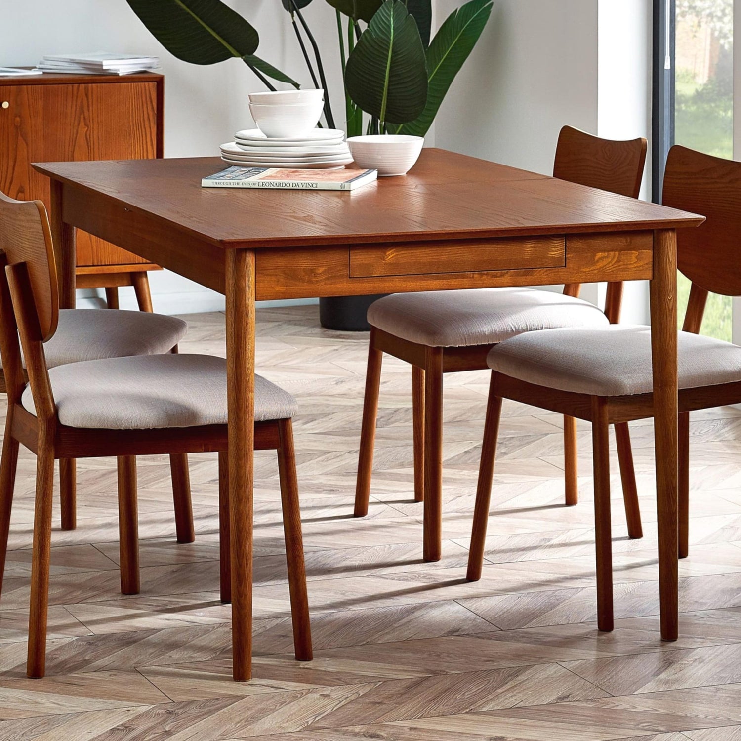 Wooden dining table with chairs in a well-lit room