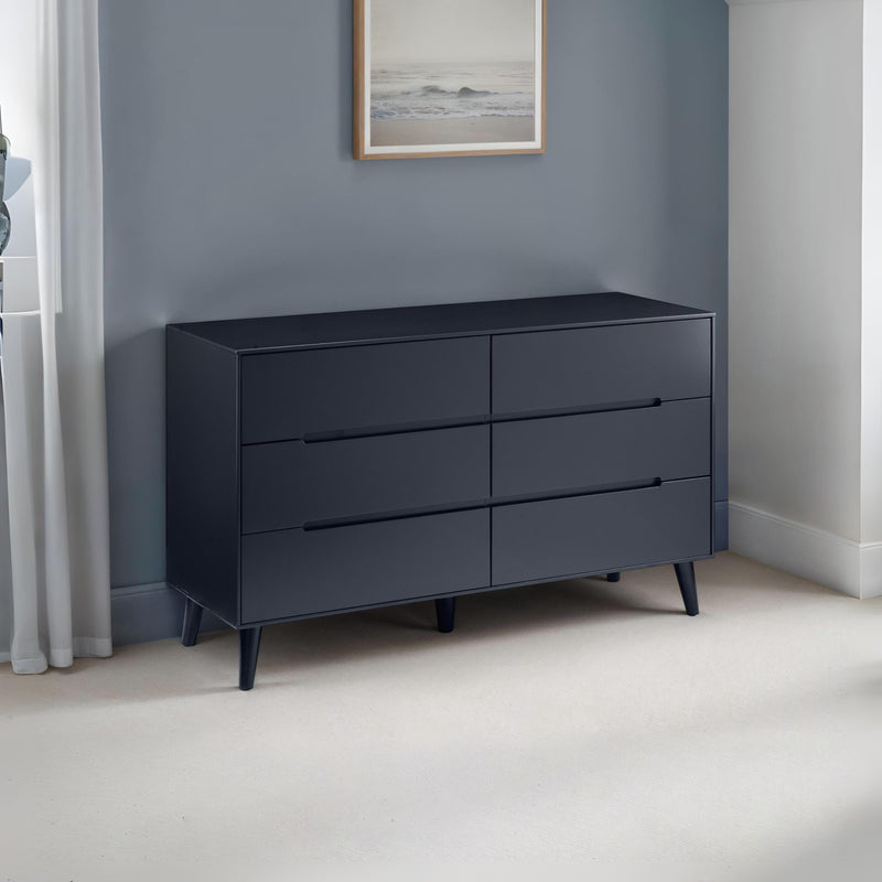 Dark blue dresser against a gray wall with a framed picture.