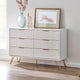 White dresser with gold legs and handles in a room setting with decor items.