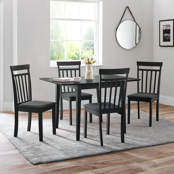 Black dining set with table and chairs in a room with a window and mirror.