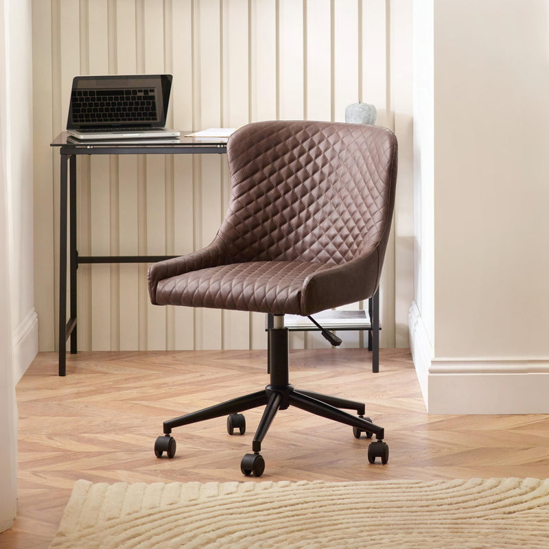 Brown quilted office chair in a home office setting with a desk and laptop.
