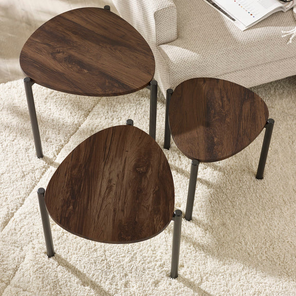 Three wooden side tables with metal legs on a carpeted floor.