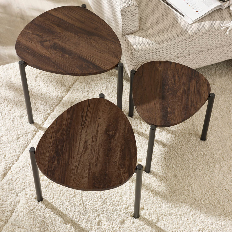 Three wooden side tables with metal legs on a carpeted floor.