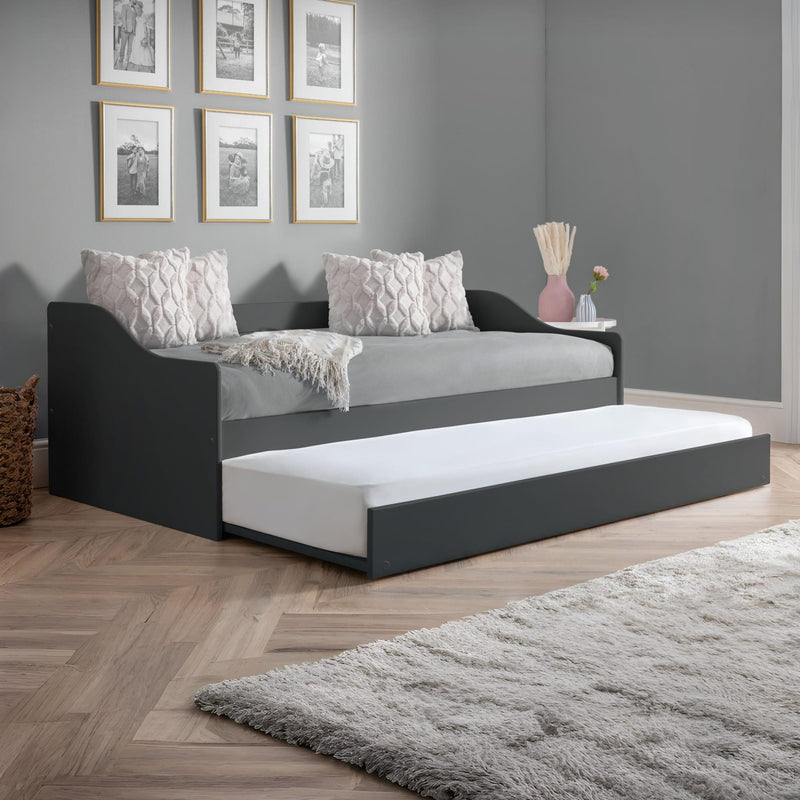 Gray sofa bed with white mattress in a room with gray walls and wooden flooring.