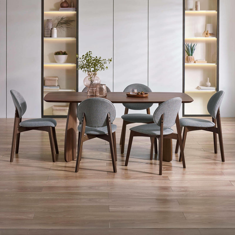 Dining room with wooden table and gray chairs in a modern interior setting.
