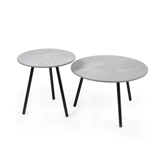 Two round side tables with a white marble-like top and black legs on a white background