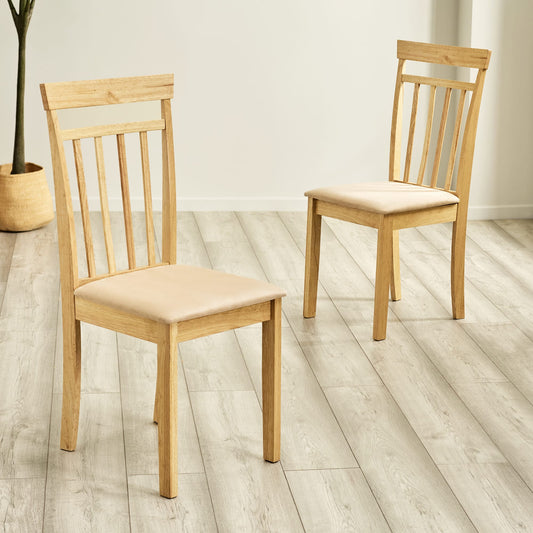 Two wooden chairs with beige cushions on a light wooden floor.