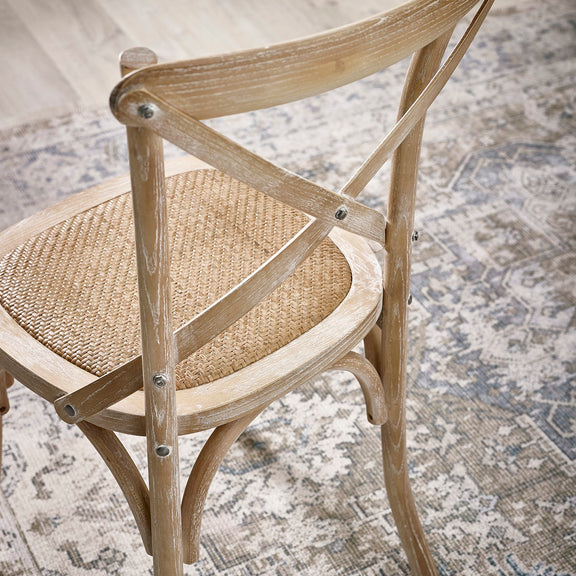Wooden chair with woven seat on a textured rug
