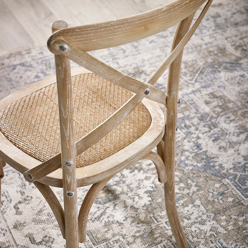 Wooden chair with woven seat on a textured rug