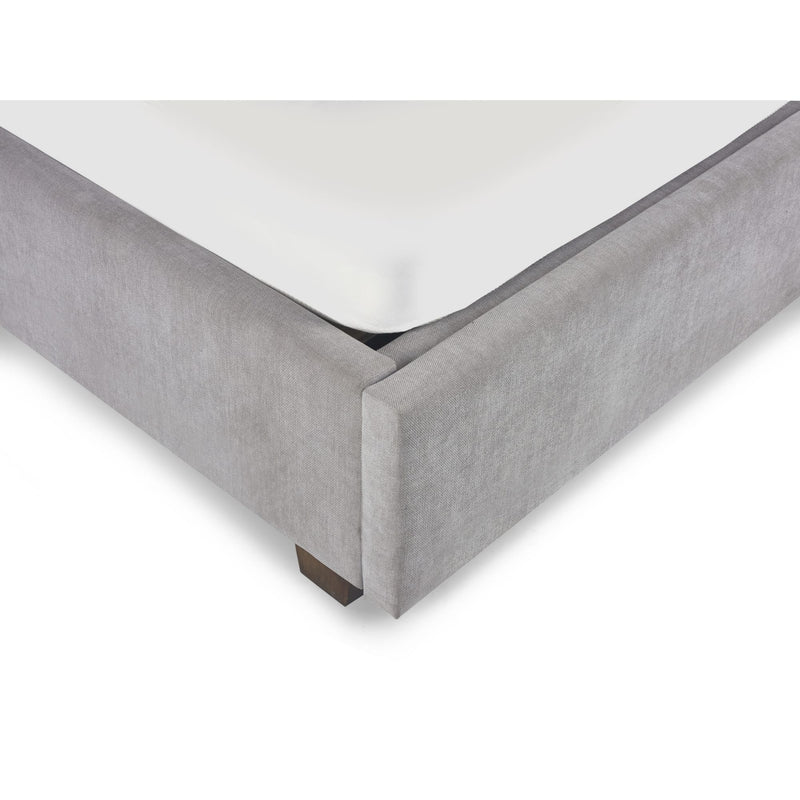 Gray upholstered bed frame corner on a white background