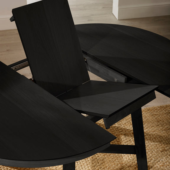 Black dining chairs and table set on a wooden floor.