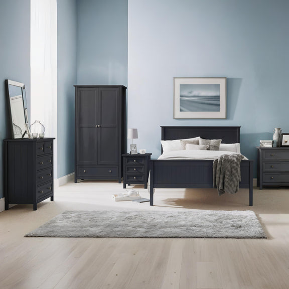 Modern bedroom with dark wood furniture against a light blue wall.