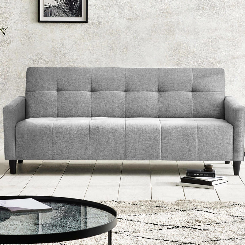 Gray sofa in a living room setting with a coffee table and books.