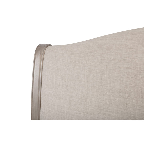 Close-up of a beige upholstered headboard on a white background