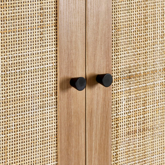 Wooden cabinet with black knobs against a textured beige background