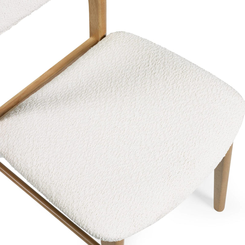 White textured cushion on a wooden chair with a white background
