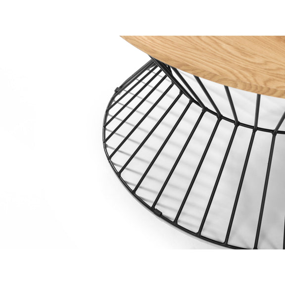 Close-up of a black metal chair seat with a wooden floor in the background