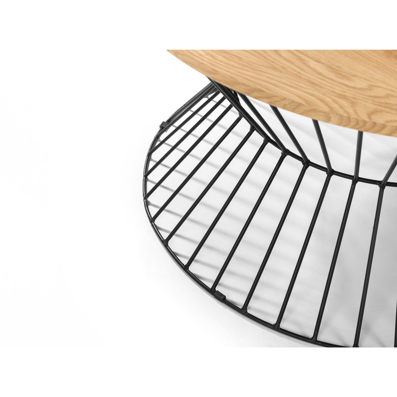 Close-up of a black metal chair seat with a wooden floor in the background