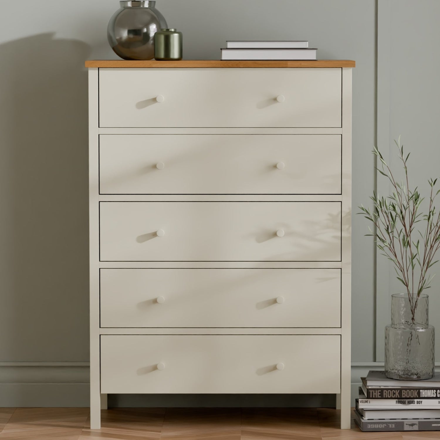 White dresser with wooden top against a neutral wall