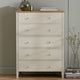 White dresser with wooden top against a neutral wall