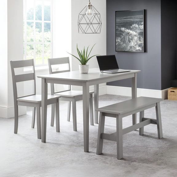 Gray dining set with table, chairs, and bench in a room with a window and artwork on the wall.