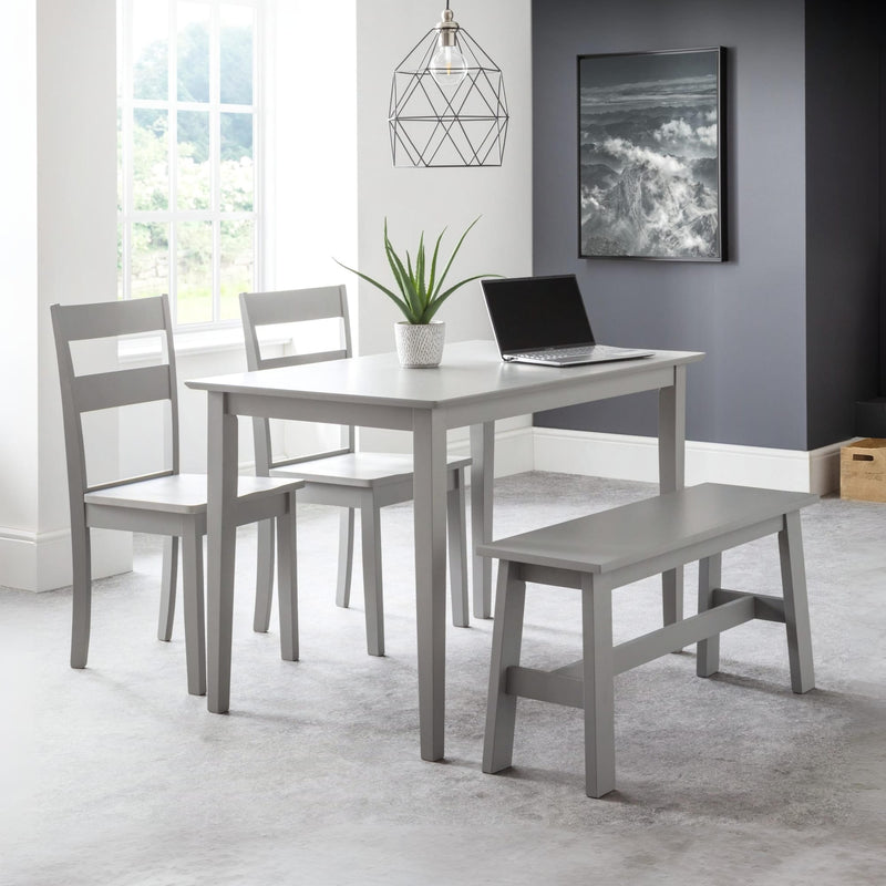 Gray dining set with table, chairs, and bench in a room with a window and artwork on the wall.