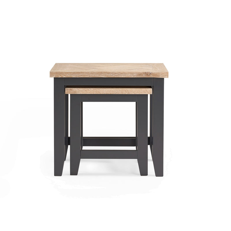 Two nesting tables with wooden tops and black bases on a white background