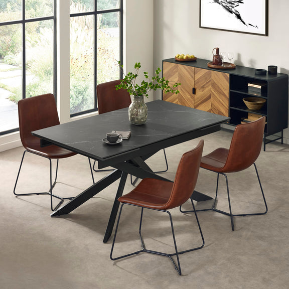 Dining room with a black table and brown chairs in a modern interior setting.