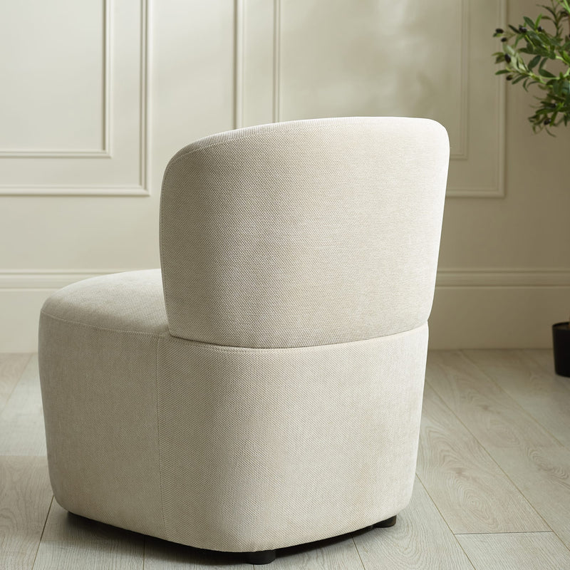 Beige armchair in a room with light-colored walls and wooden floor.