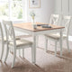 Dining room with a wooden table and white chairs on a wooden floor.