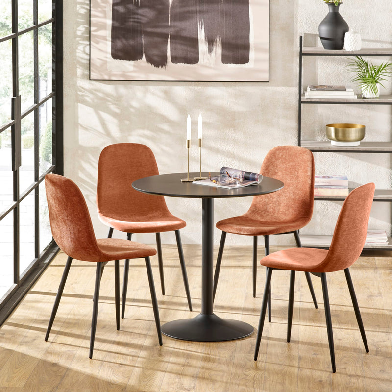 Dining room with round table and four brown chairs in a modern interior setting.