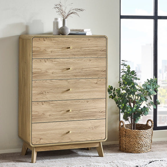 Wooden dresser with four drawers in a room with a plant and window.