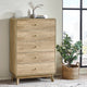 Wooden dresser with four drawers in a room with a plant and window.