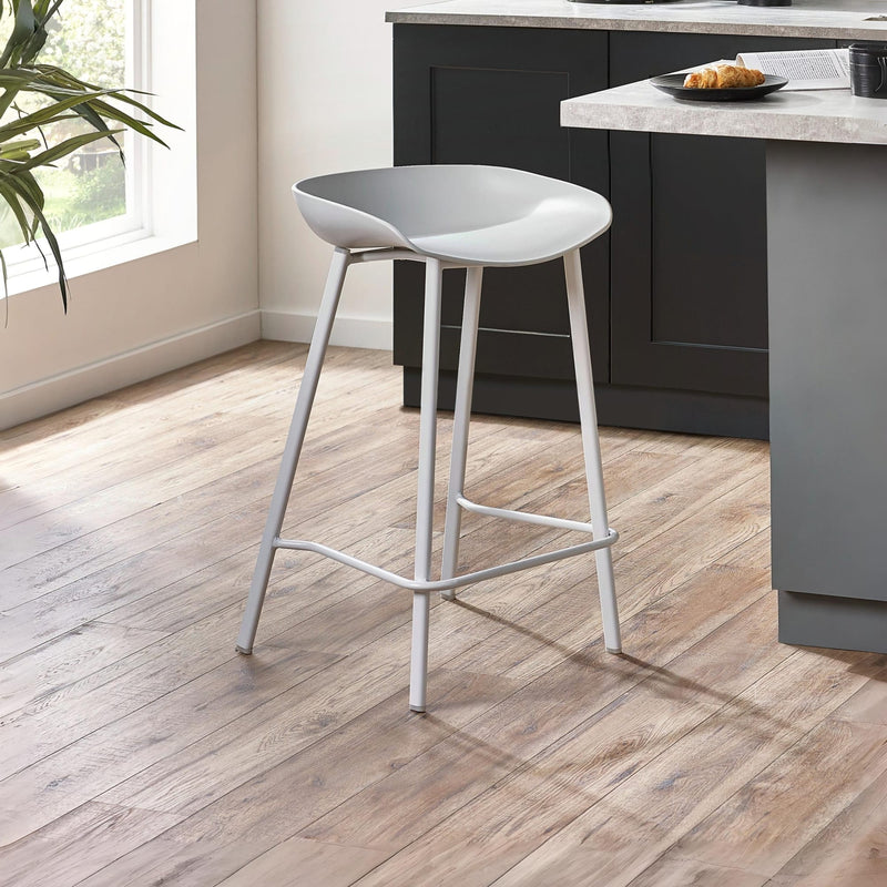 White bar stool on a wooden floor in a kitchen setting