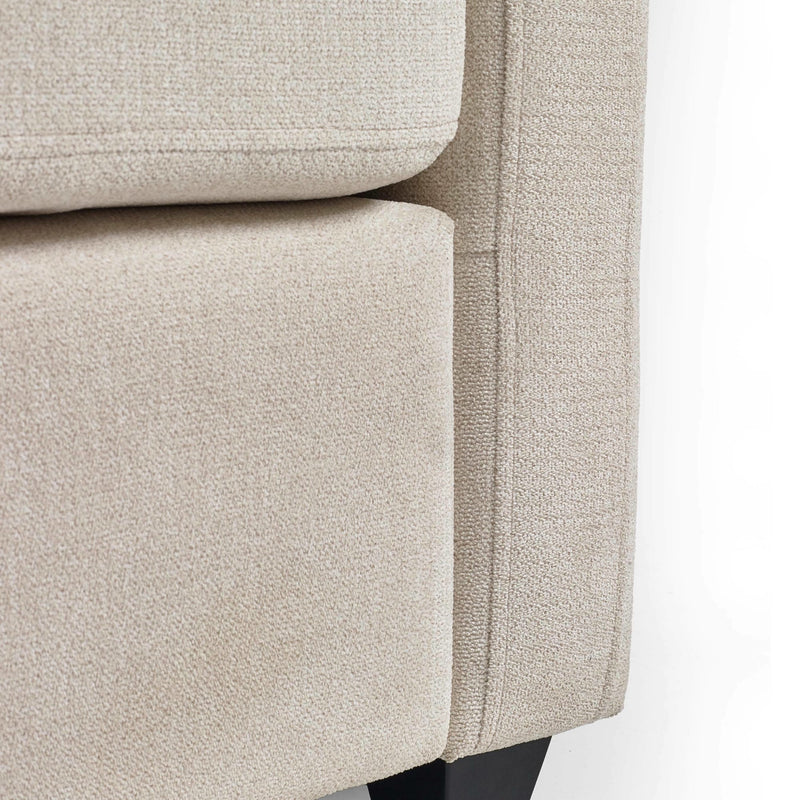 Close-up of a beige upholstered chair corner on a white background